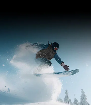 A snowboarder carving through powder